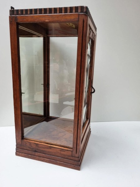 Zijaanzicht van compacte eikenhouten display case met glazen zijpanelen